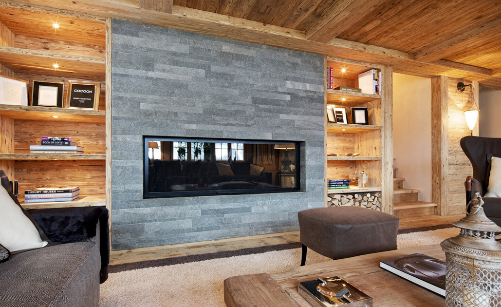 Cheminéeverkleidung in Naturstein in modernem Chalet