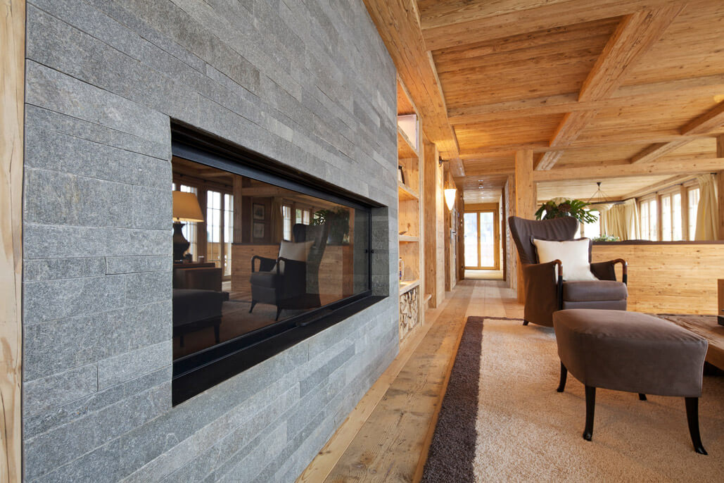 Cheminéeverkleidung in Naturstein in modernem Chalet