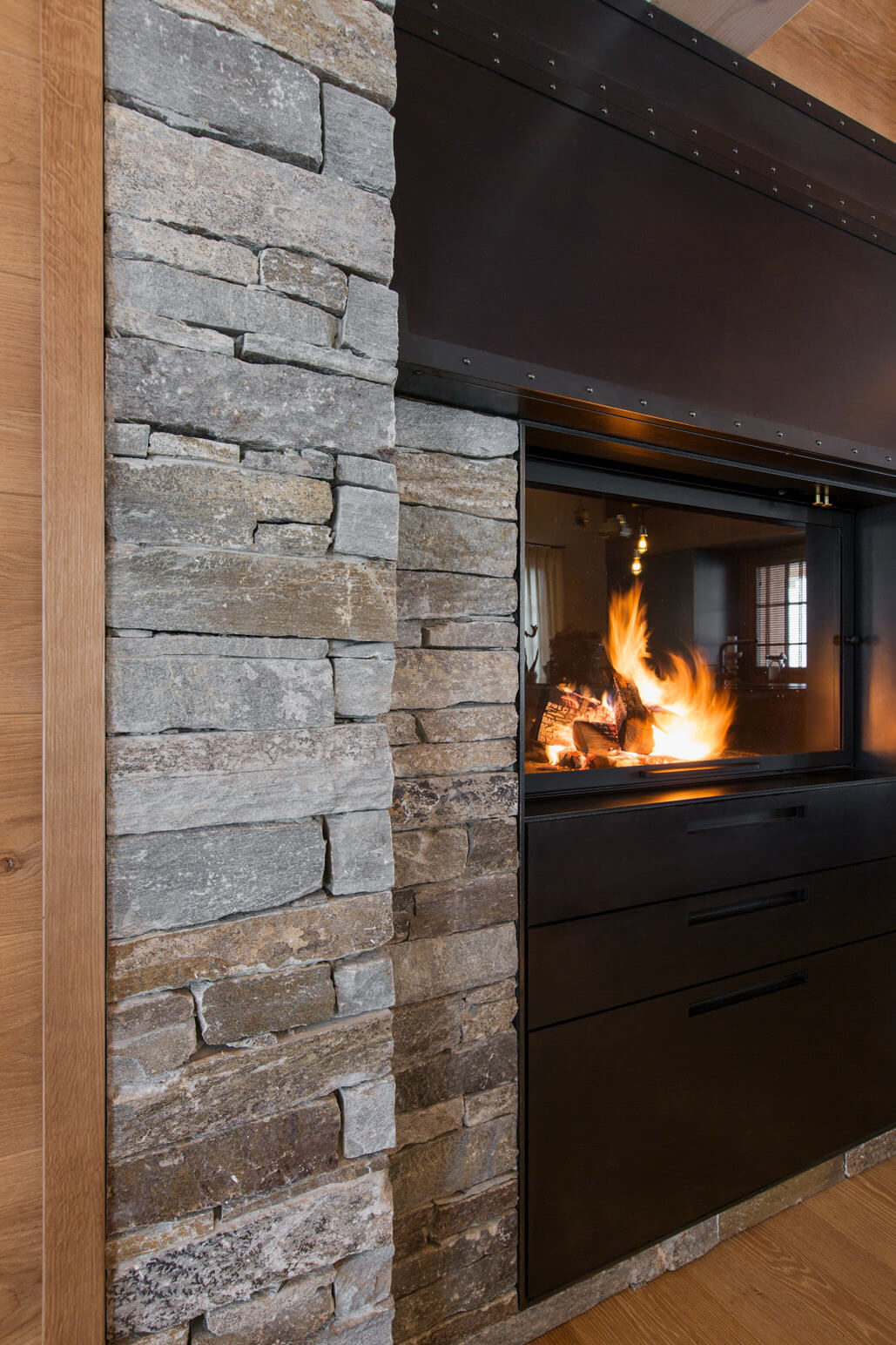 Ein Kaminofen eingefasst in Naturstein